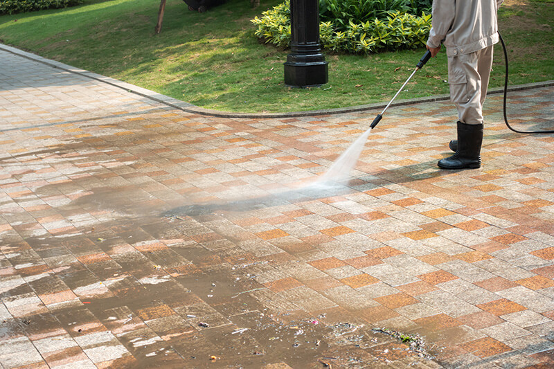 A person using a pressure washer to clean